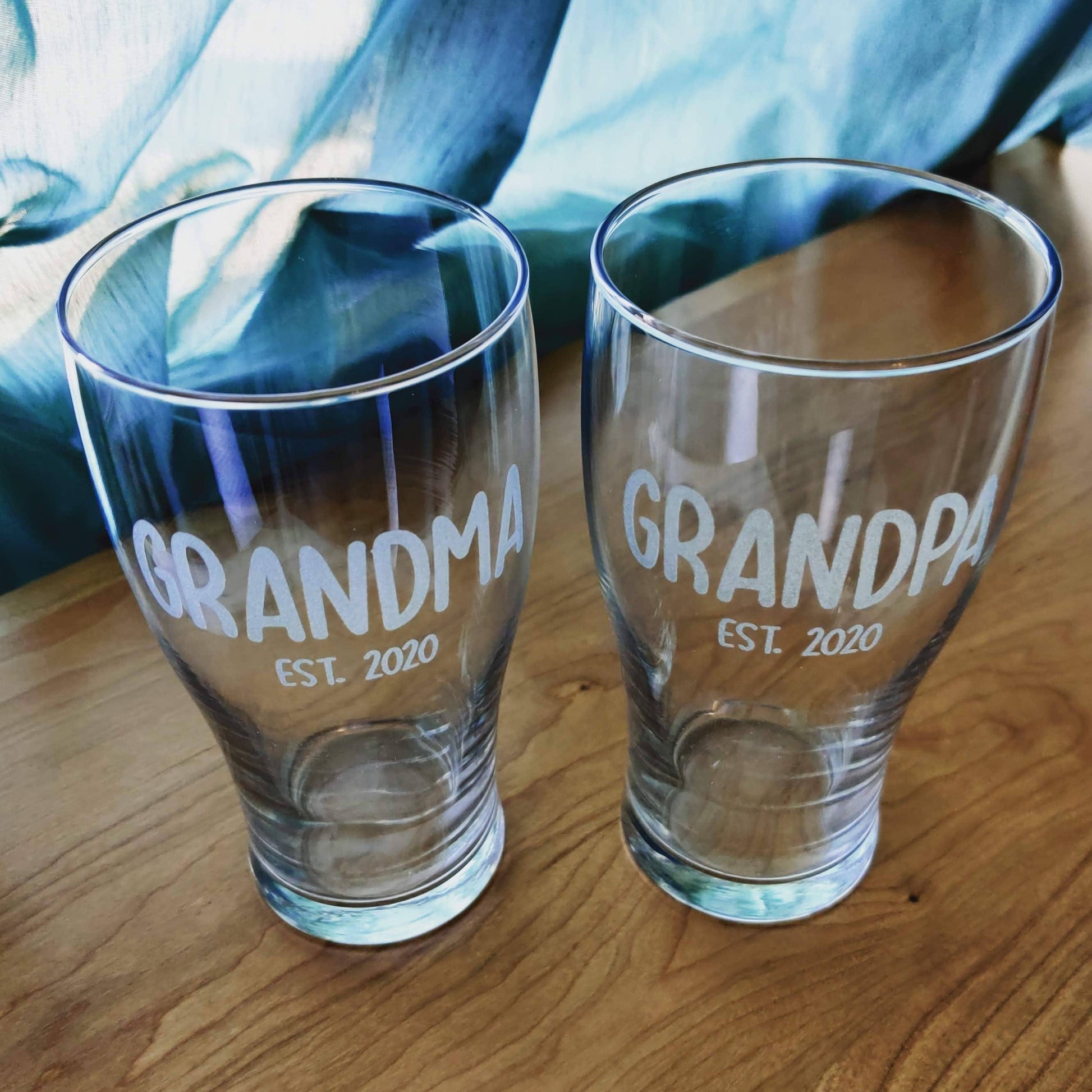 Two pint glasses engraved with matching Grandma and Grandpa est. 2020 text